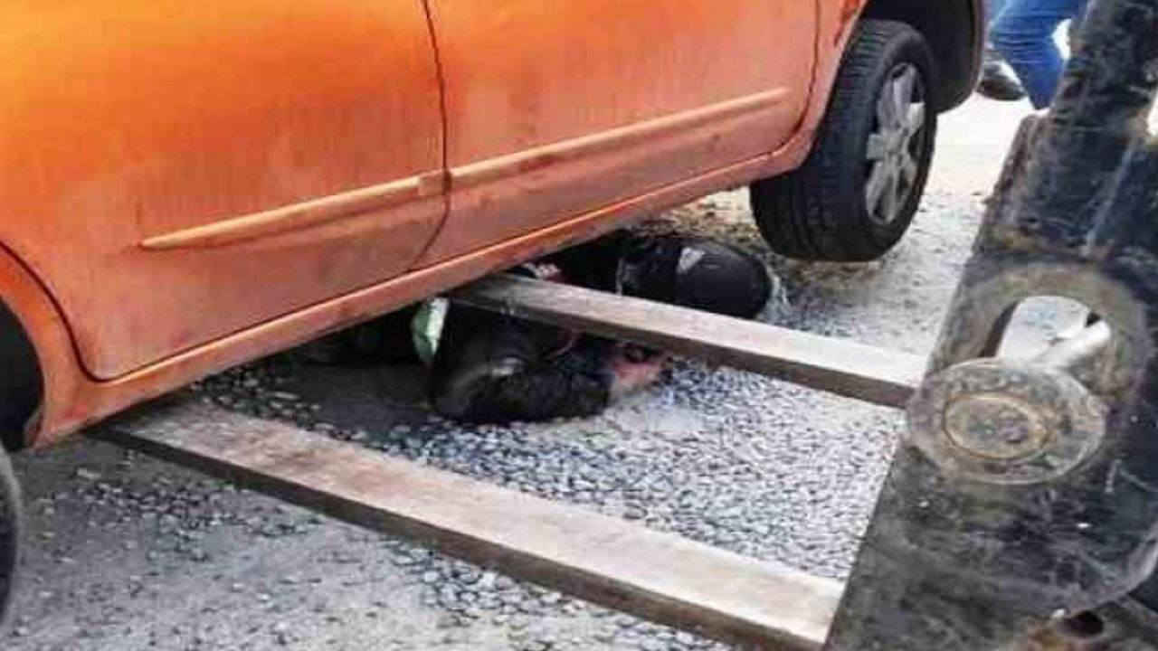 Mıcırda kayan motosiklet otomobilin altına girdi